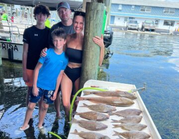 Family showing off their catch from a day out on a fishing charter in Crystal River, FL.