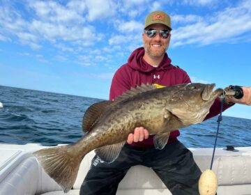 Man holding up a fish he caught while out on the water with a Salt River Outfitters fishing charter in Crystal River, FL.