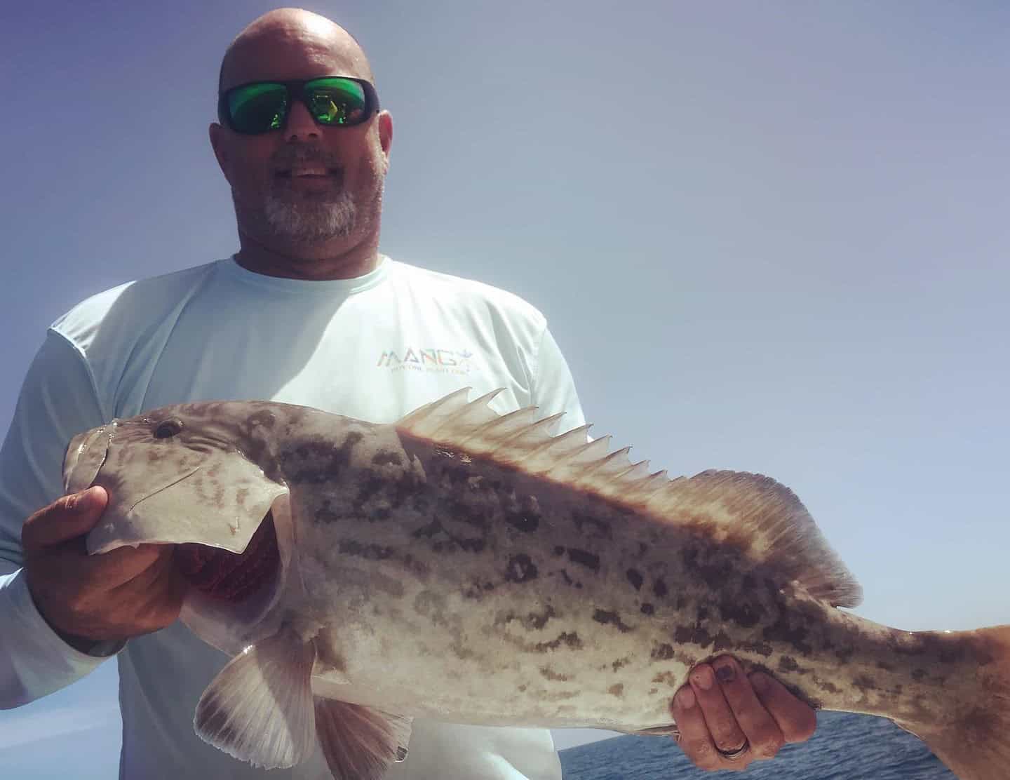 Man holding up a gag grouper he caught while on a fishing charter with Salt River Outfitters in Crystal River, FL.