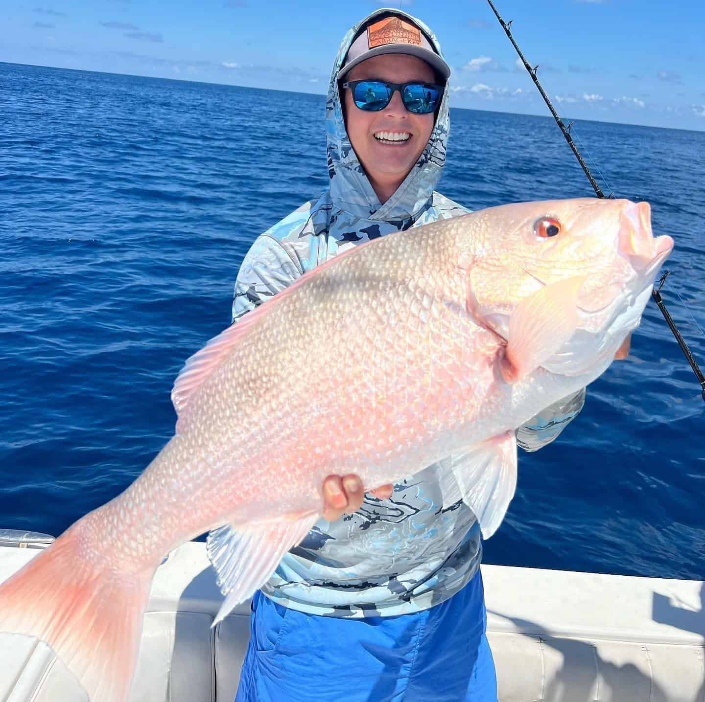 Person holding up a red snapper caught during an offshore fishing charter.