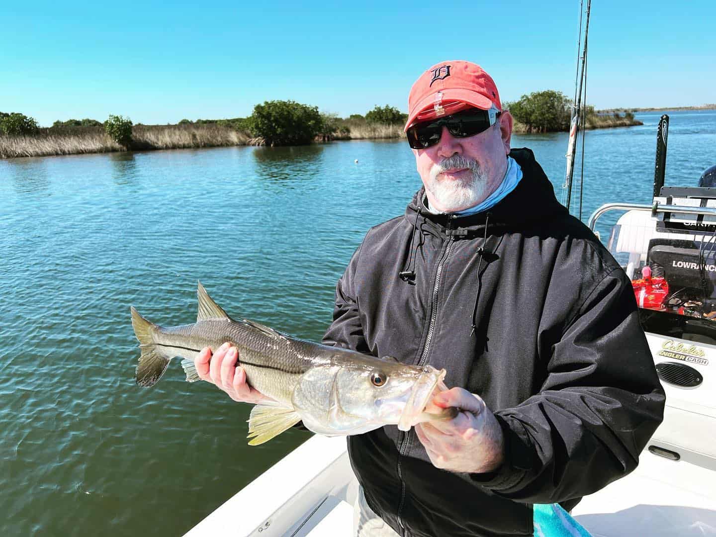 Man holding up a snook he caught while on a fishing charter in Crystal River, FL.