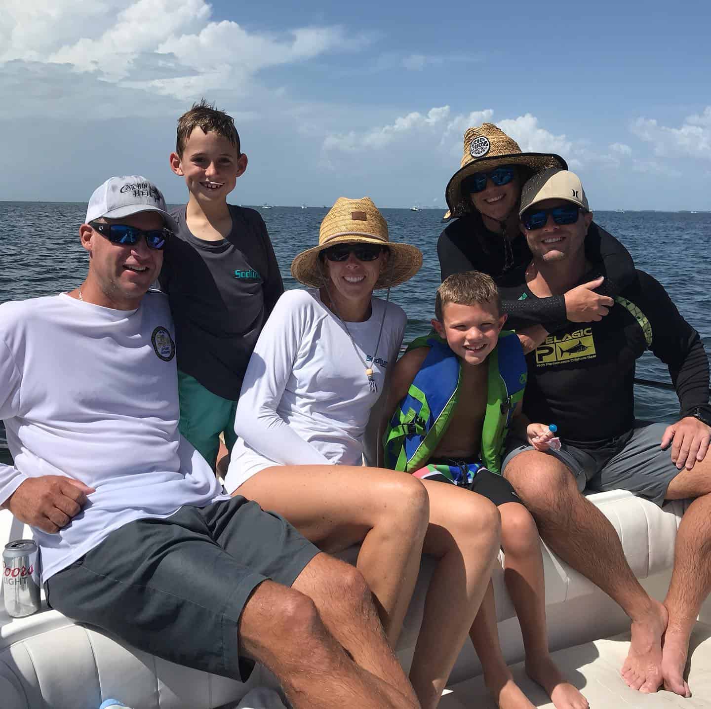 Family enjoying a fishing trip on a boat in Crystal River, FL with Salt River Outfitters, smiling under the sun with the Gulf waters in the background.