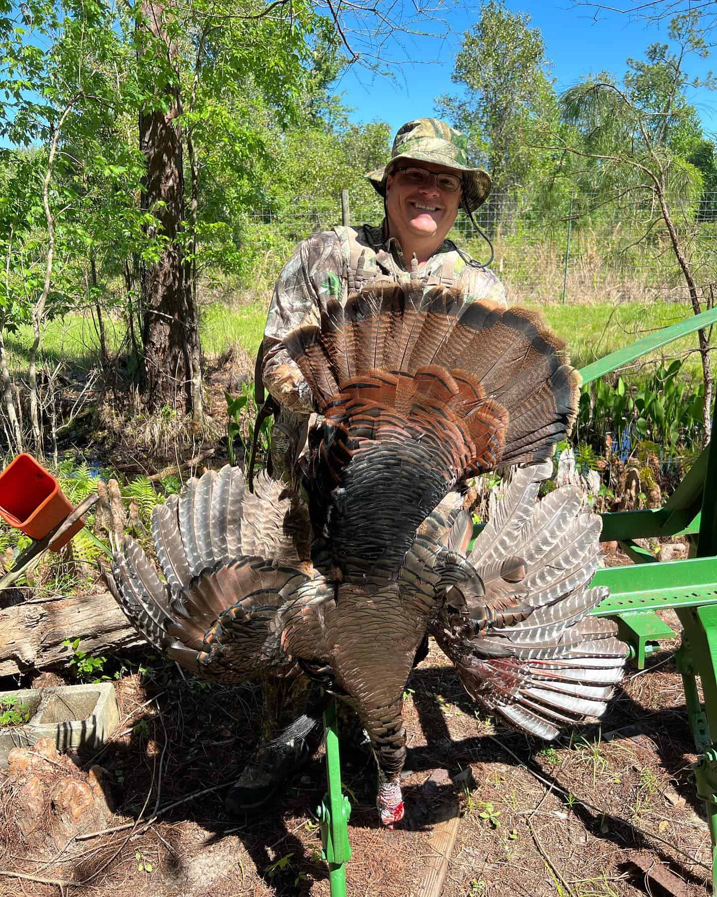 Hunter proudly holding an Osceola turkey in the Florida wilderness.