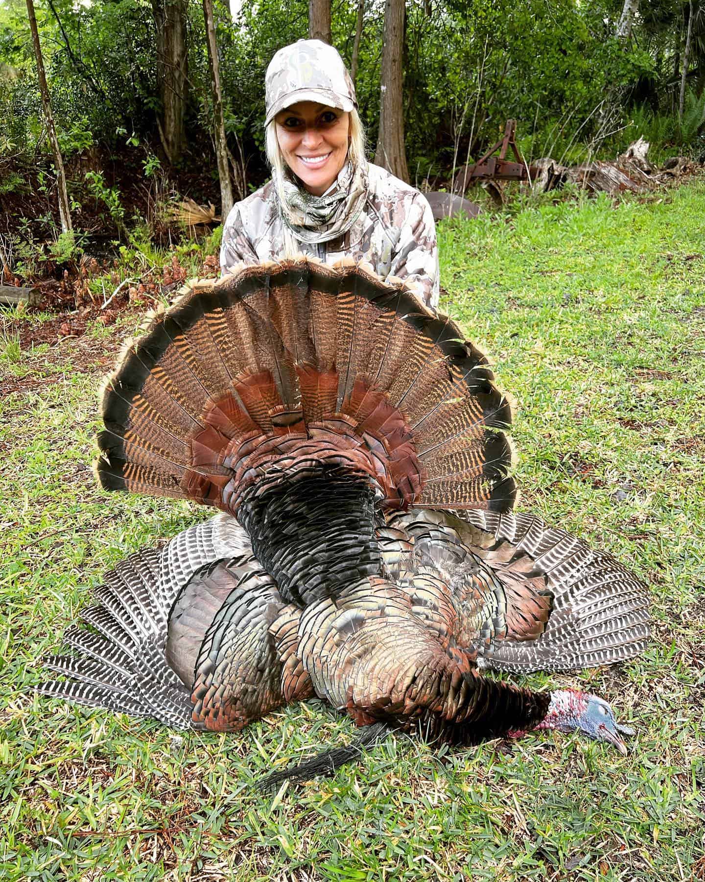 Hunter holding up a prize turkey she caught while on a hunting trip with Salt River Outfitters.